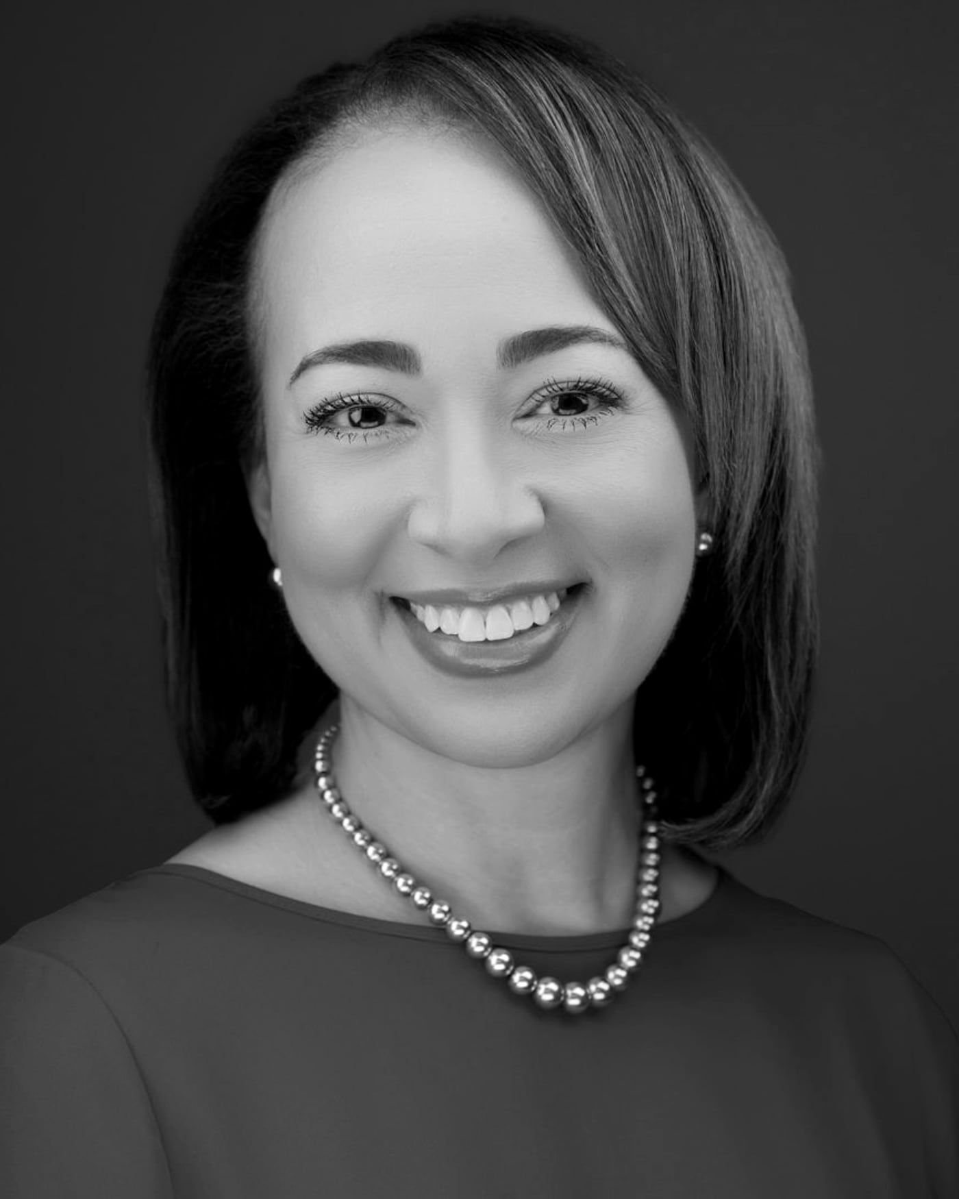 Black-and-white fine-art portrait of a woman wearing a pearl necklace.